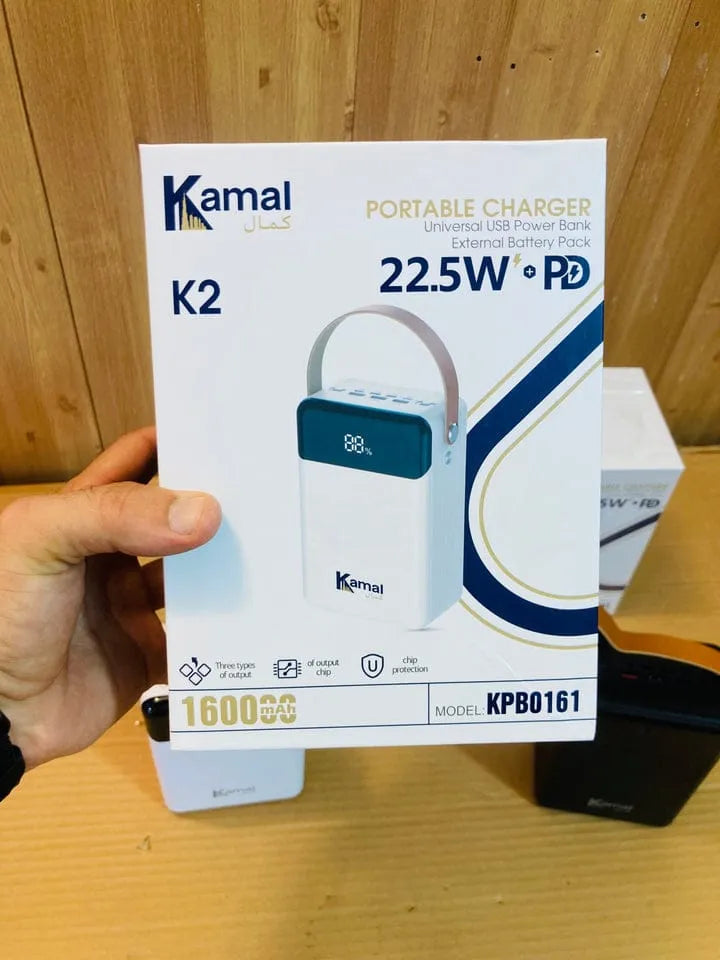 Kamal portable charger packaging held by a hand on a wooden surface