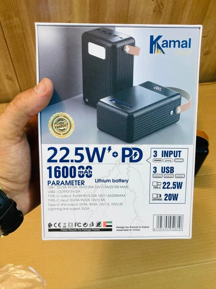 Kamal power bank packaging held by a hand on a wooden surface